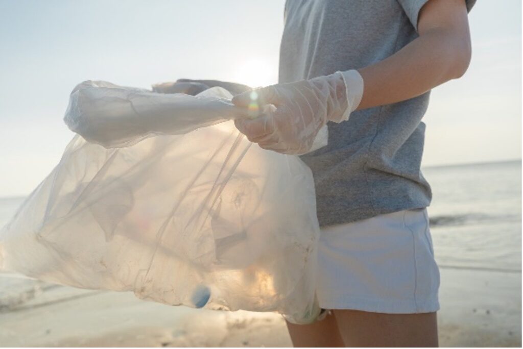 Volunteer collecting plastic at the beach