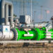 Green Hydrogen renewable energy production pipeline. It shows a large, silver pipe with two sections painted green and the words, "H2 green hydrogen".